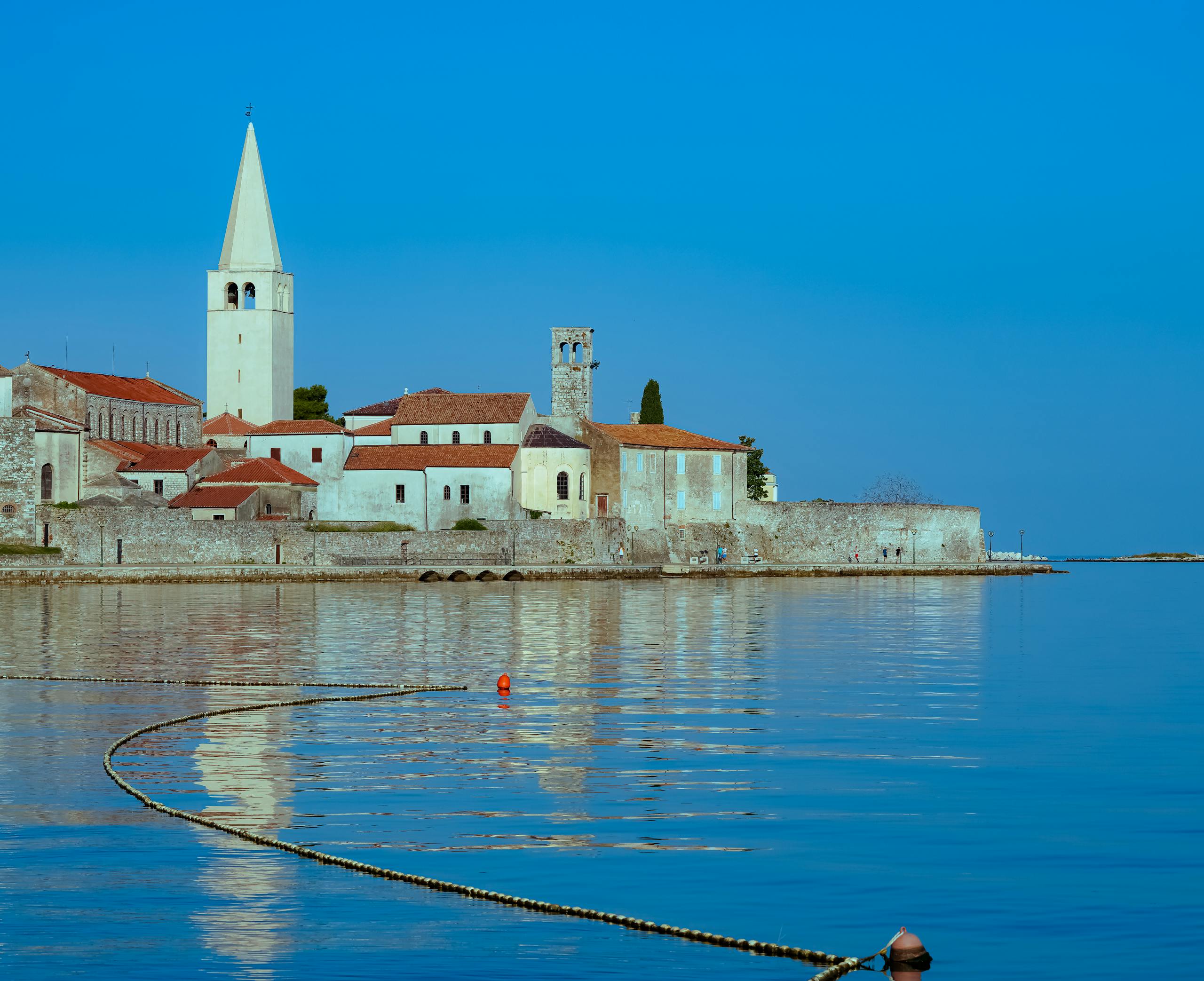 A serene view of Poreč's coastline featuring historical buildings and the St. Euphrasius Basilica.