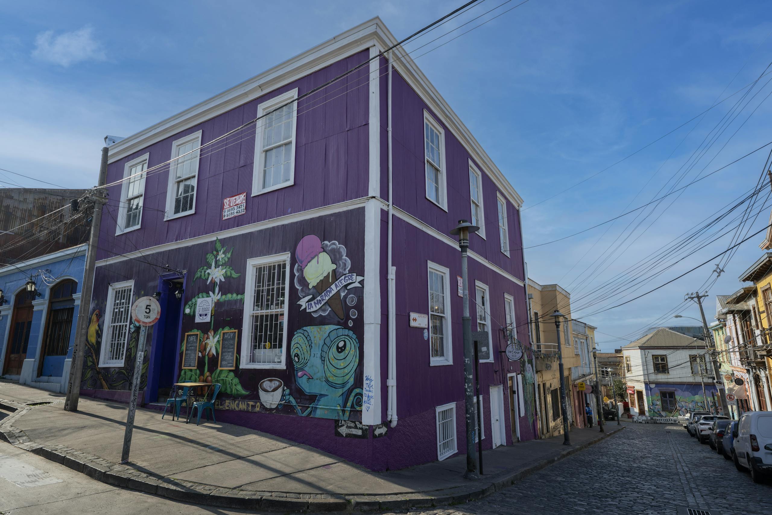 Colorful mural-painted building on a lively street in Valparaíso, Chile.