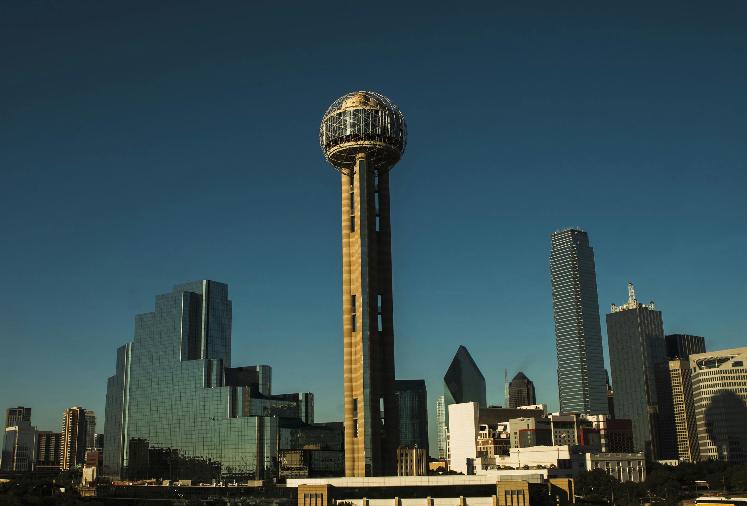 Iconic Dallas skyline with Reunion Tower under a clear blue sky.