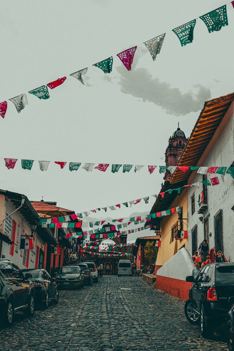 Traditional Mexican street adorned with colorful flags and historic architecture.