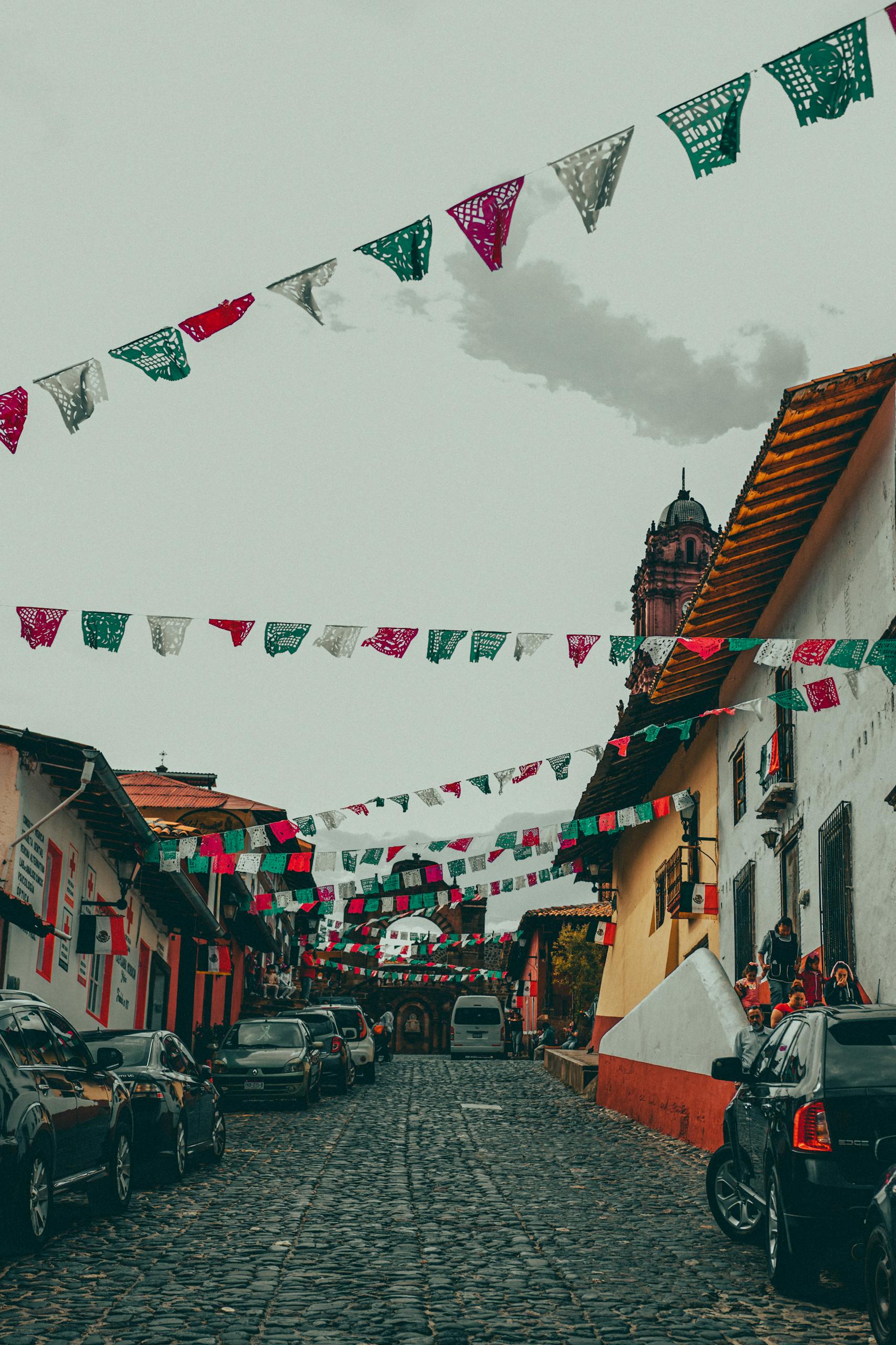 Traditional Mexican street adorned with colorful flags and historic architecture.