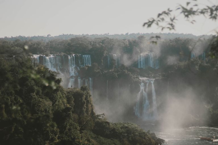 Picturesque view of cascade with pure water and pond surrounded by mounts with green trees in overcast weather in daylight