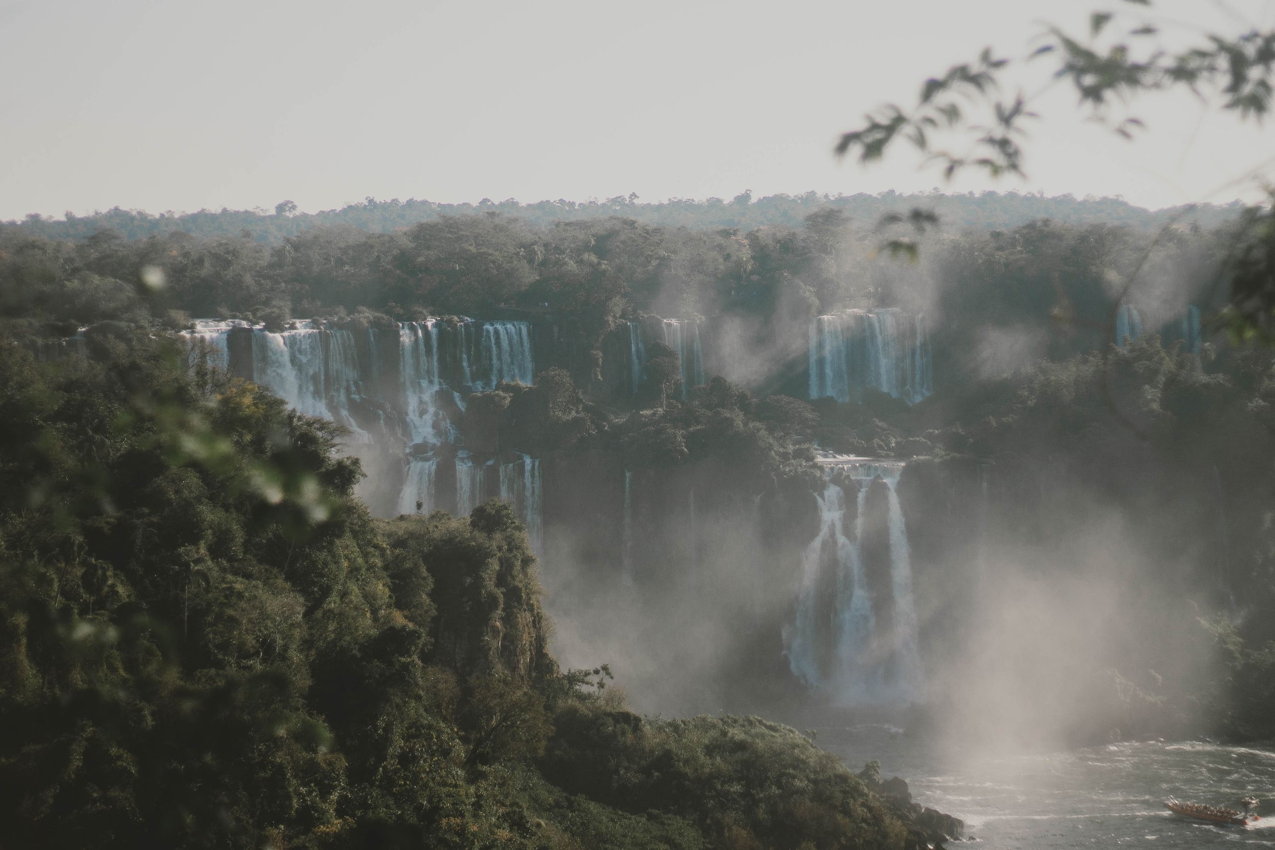 Picturesque view of cascade with pure water and pond surrounded by mounts with green trees in overcast weather in daylight