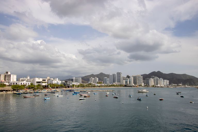 Skyline of Santa Marta, Colombia, with boats in the foreground and mountains in the background.